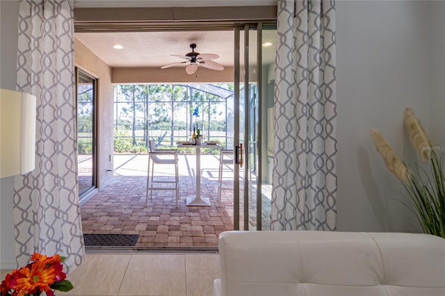 doorway to outside featuring tile patterned flooring and ceiling fan