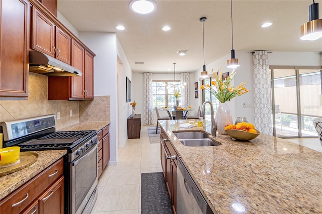 kitchen with sink, hanging light fixtures, light stone countertops, tasteful backsplash, and stainless steel appliances