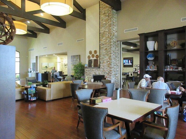 333 Navarra Ln, Davenport, FL 33837 - dining room featuring a fireplace, beam ceiling, a towering ceiling, and visible vents