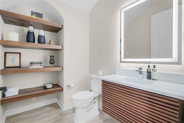 bathroom with vanity, toilet, and hardwood / wood-style flooring