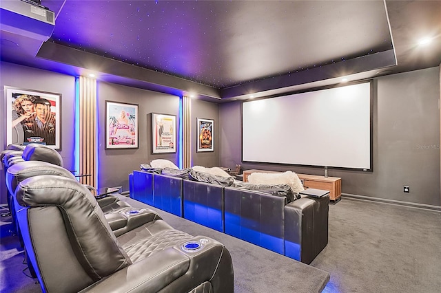 home theater room with a tray ceiling and carpet flooring