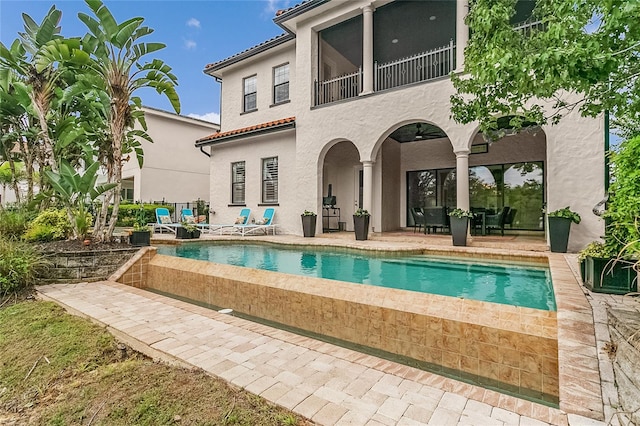 back of property featuring a balcony and a patio area