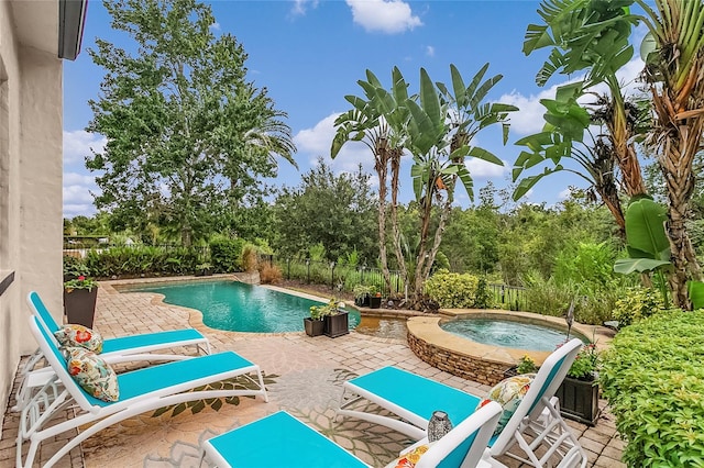 view of pool with a patio area and an in ground hot tub