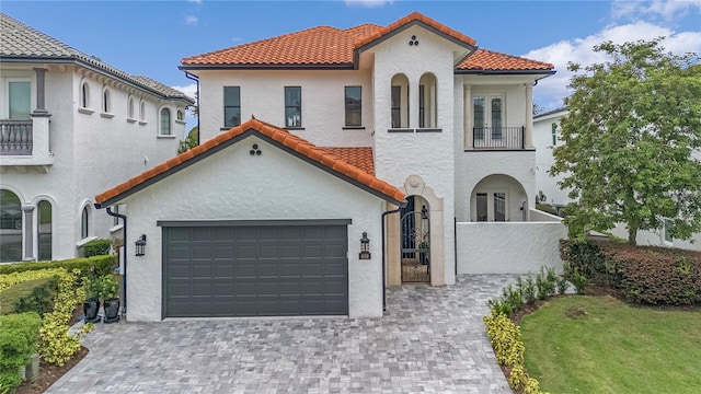 mediterranean / spanish-style house featuring a garage and a balcony