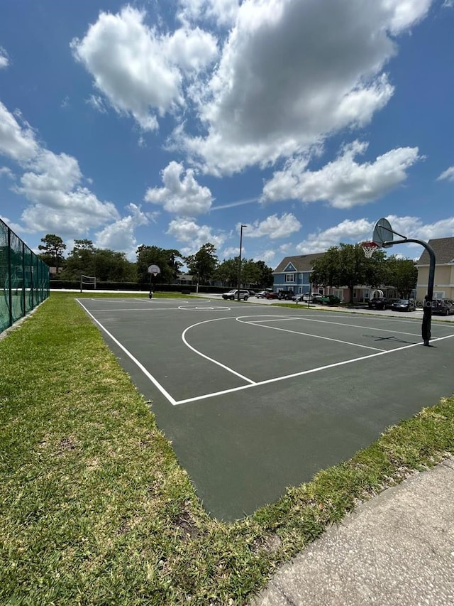 view of sport court featuring a lawn