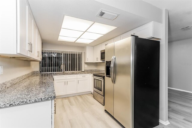 kitchen with white cabinetry, light wood-type flooring, sink, light stone countertops, and appliances with stainless steel finishes