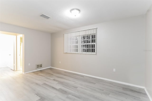 empty room featuring a textured ceiling and light wood-type flooring