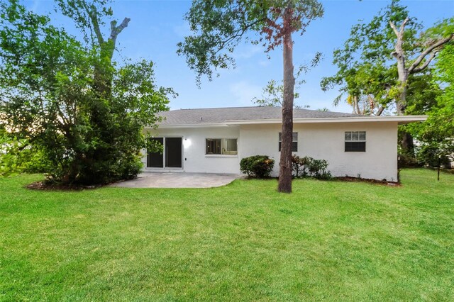 back of property featuring a patio and a yard