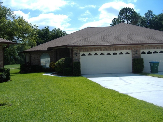 single story home featuring a garage and a front lawn