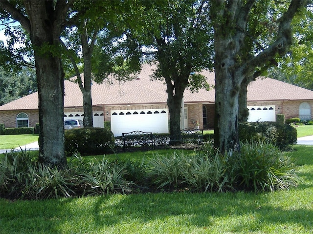 ranch-style home with a garage and a front lawn