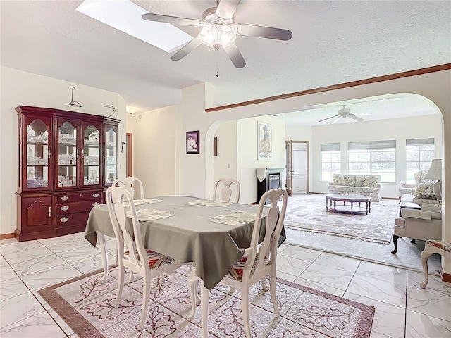 dining area featuring ceiling fan and a textured ceiling