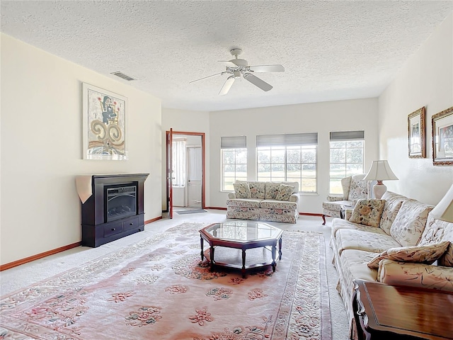 living room with a healthy amount of sunlight, light colored carpet, a textured ceiling, and ceiling fan