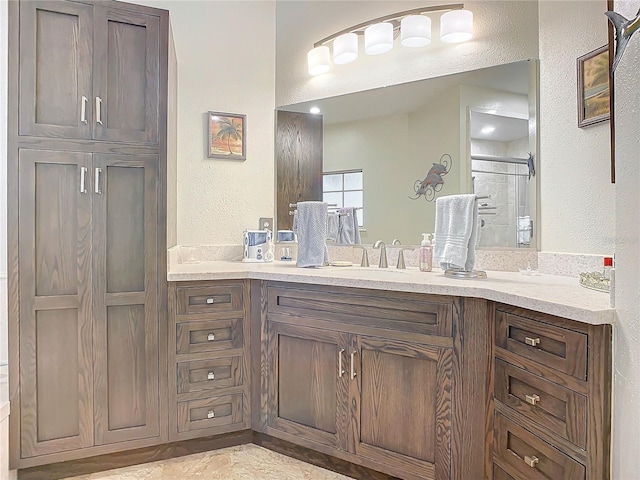 bathroom featuring vanity and a shower with door