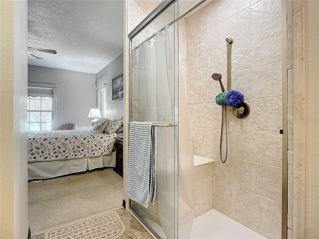 bathroom with a shower with shower door and a textured ceiling