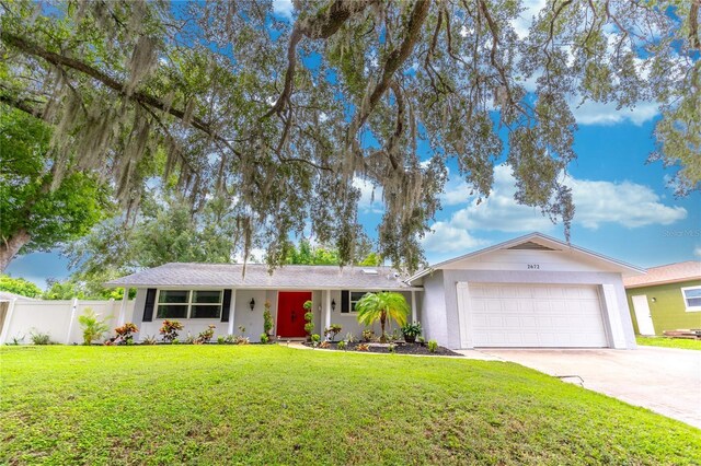 single story home featuring a garage and a front yard