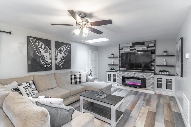 living room with a fireplace, wood-type flooring, and ceiling fan