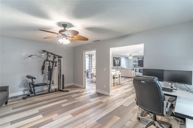 office space with ceiling fan, a textured ceiling, and light hardwood / wood-style flooring