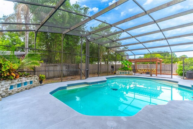 view of swimming pool with glass enclosure and a patio area