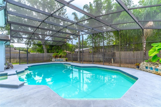 view of swimming pool with glass enclosure and a patio area