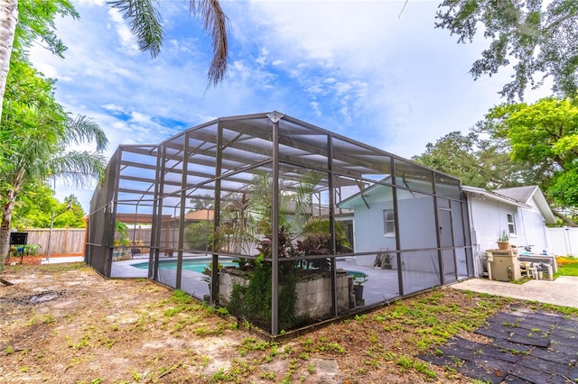 rear view of property with a patio area, a fenced in pool, and a lanai