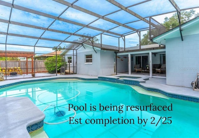 view of swimming pool featuring an in ground hot tub, a patio area, and glass enclosure