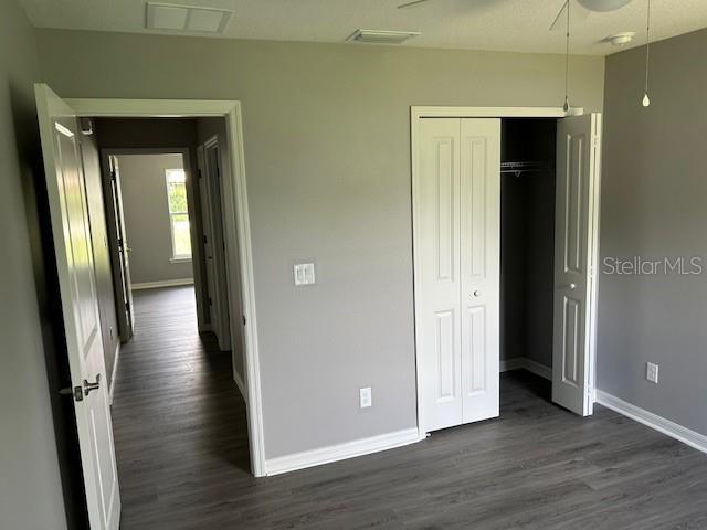 unfurnished bedroom featuring a closet and dark hardwood / wood-style floors