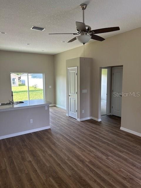 spare room with a textured ceiling, ceiling fan, sink, and dark hardwood / wood-style floors