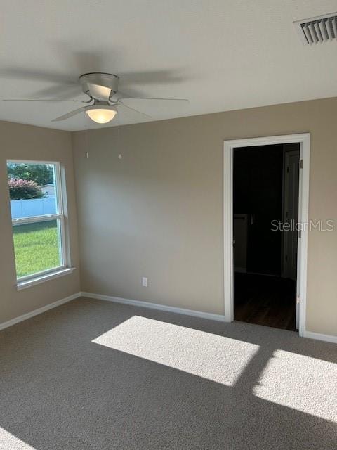 empty room with ceiling fan and carpet