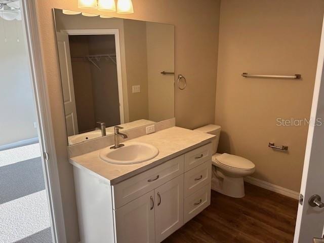 bathroom with hardwood / wood-style flooring, vanity, and toilet