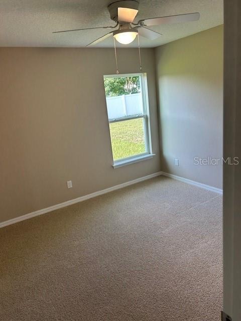 empty room featuring ceiling fan and carpet floors