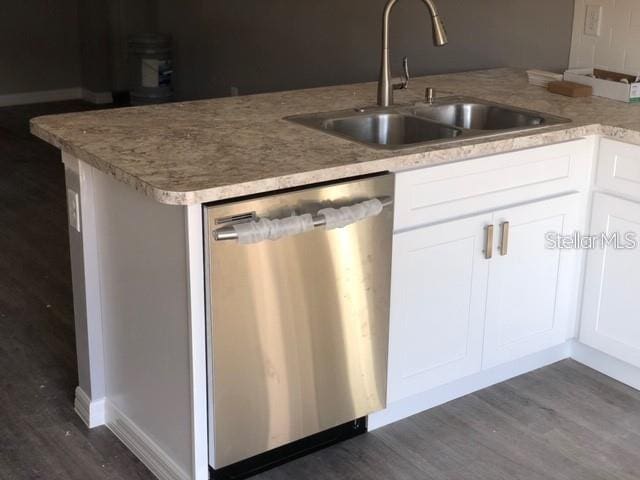 kitchen featuring kitchen peninsula, dishwasher, dark hardwood / wood-style floors, white cabinets, and sink