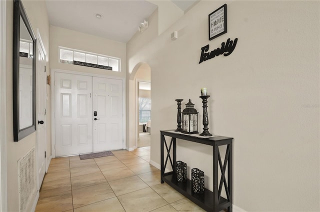 foyer with light tile patterned floors and a towering ceiling