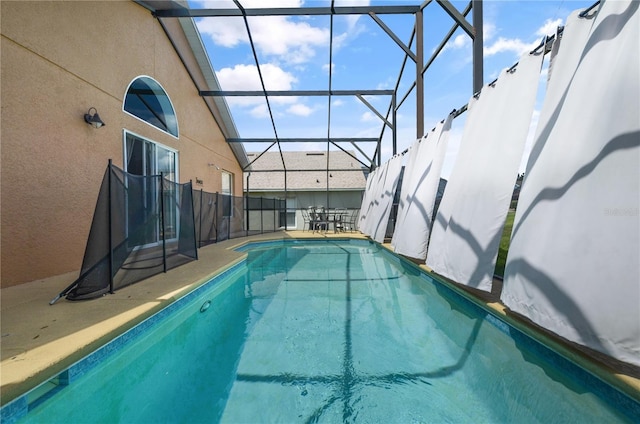 view of pool with glass enclosure