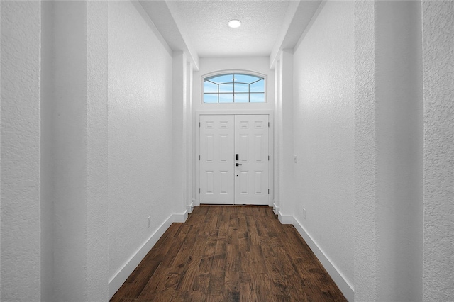 doorway featuring dark wood-type flooring and a textured ceiling