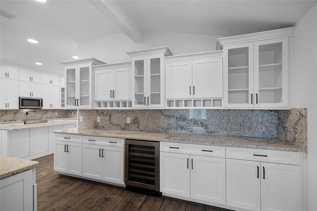 kitchen with tasteful backsplash, wine cooler, light stone countertops, and white cabinets