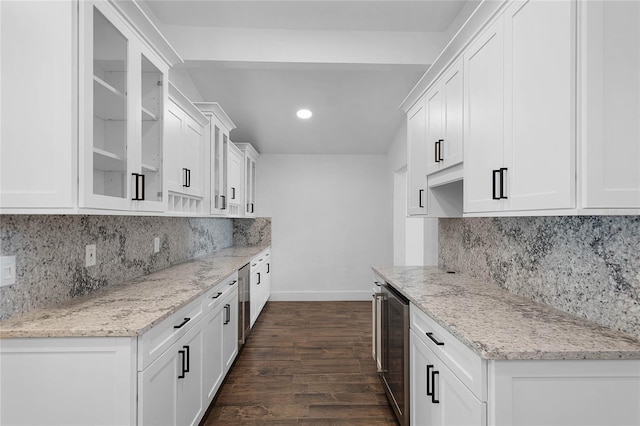 kitchen with light stone counters, white cabinets, and dark hardwood / wood-style floors