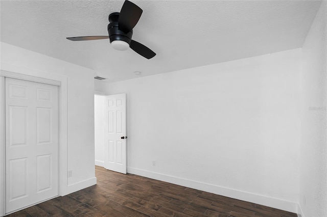 unfurnished bedroom featuring a textured ceiling, a closet, ceiling fan, and dark wood-type flooring