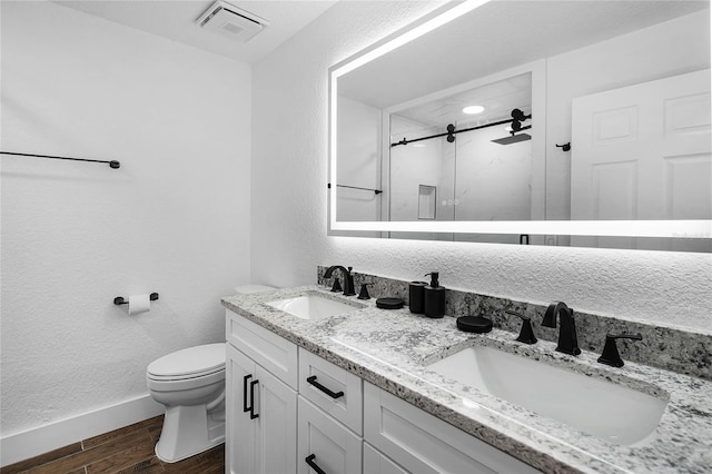 bathroom with vanity, toilet, and a shower with door