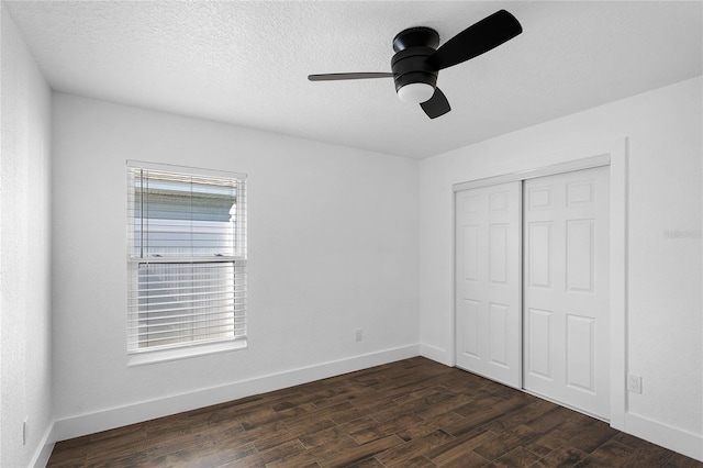 unfurnished bedroom with ceiling fan, dark hardwood / wood-style floors, a textured ceiling, and a closet