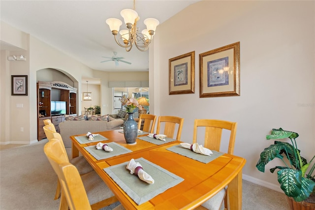 dining area featuring ceiling fan with notable chandelier and carpet flooring