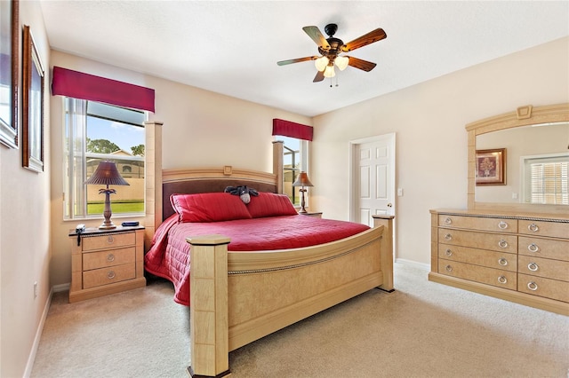 carpeted bedroom with ceiling fan and multiple windows