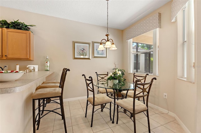 dining space featuring a textured ceiling and light tile patterned floors