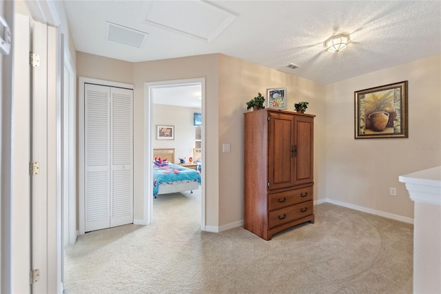 hallway with light colored carpet and a textured ceiling