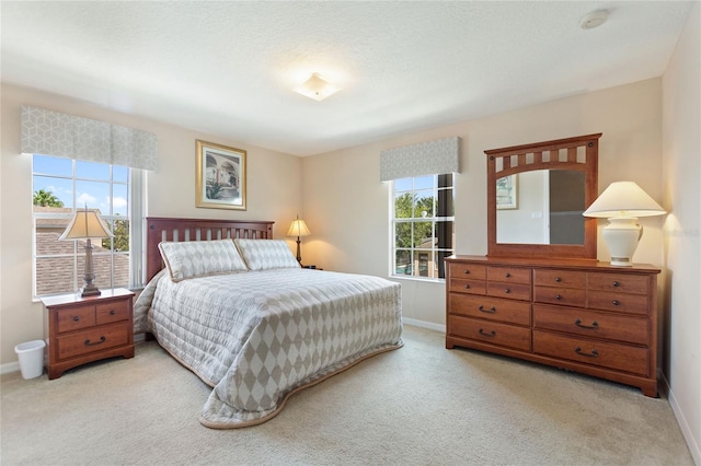 bedroom featuring light carpet and a textured ceiling