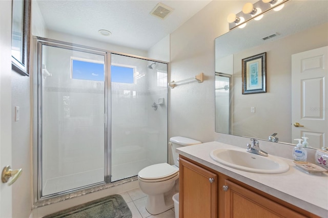 bathroom featuring a shower with door, tile patterned flooring, vanity, a textured ceiling, and toilet