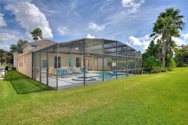 rear view of property with a patio, glass enclosure, and a lawn