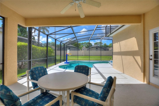 view of pool featuring ceiling fan, a yard, glass enclosure, and a patio area