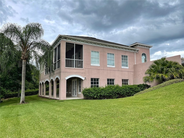 back of house featuring a patio area and a lawn