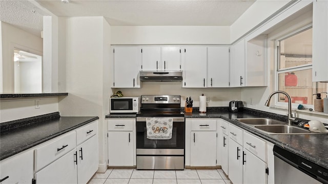 kitchen with white cabinetry, sink, appliances with stainless steel finishes, a textured ceiling, and light tile patterned floors