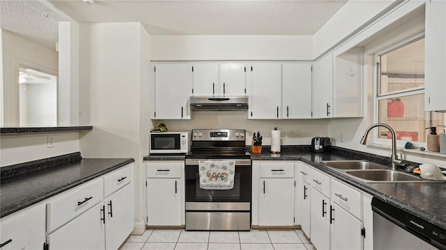 kitchen with sink, stainless steel appliances, white cabinets, and light tile patterned flooring